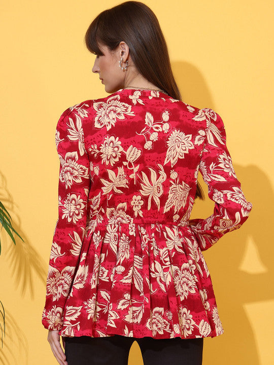 Woman wearing a maroon floral print long sleeve top with pleated waist, back view