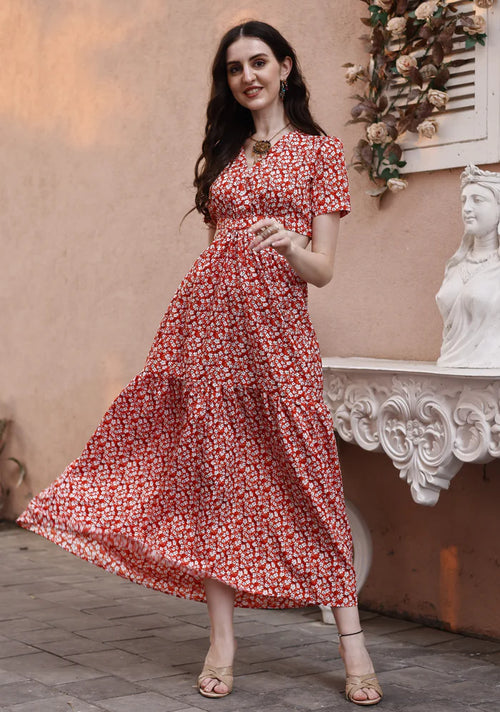 Woman wearing red floral maxi dress with short sleeves, posing outdoors on stone pavement