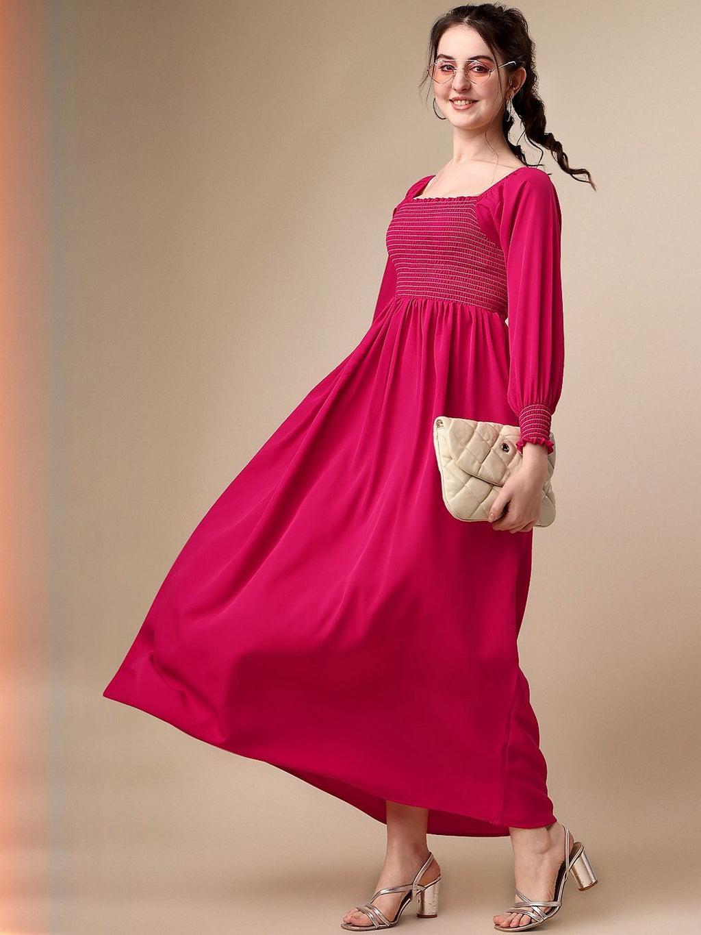 Woman in a long-sleeve hot pink maxi dress with a quilted clutch and heeled sandals