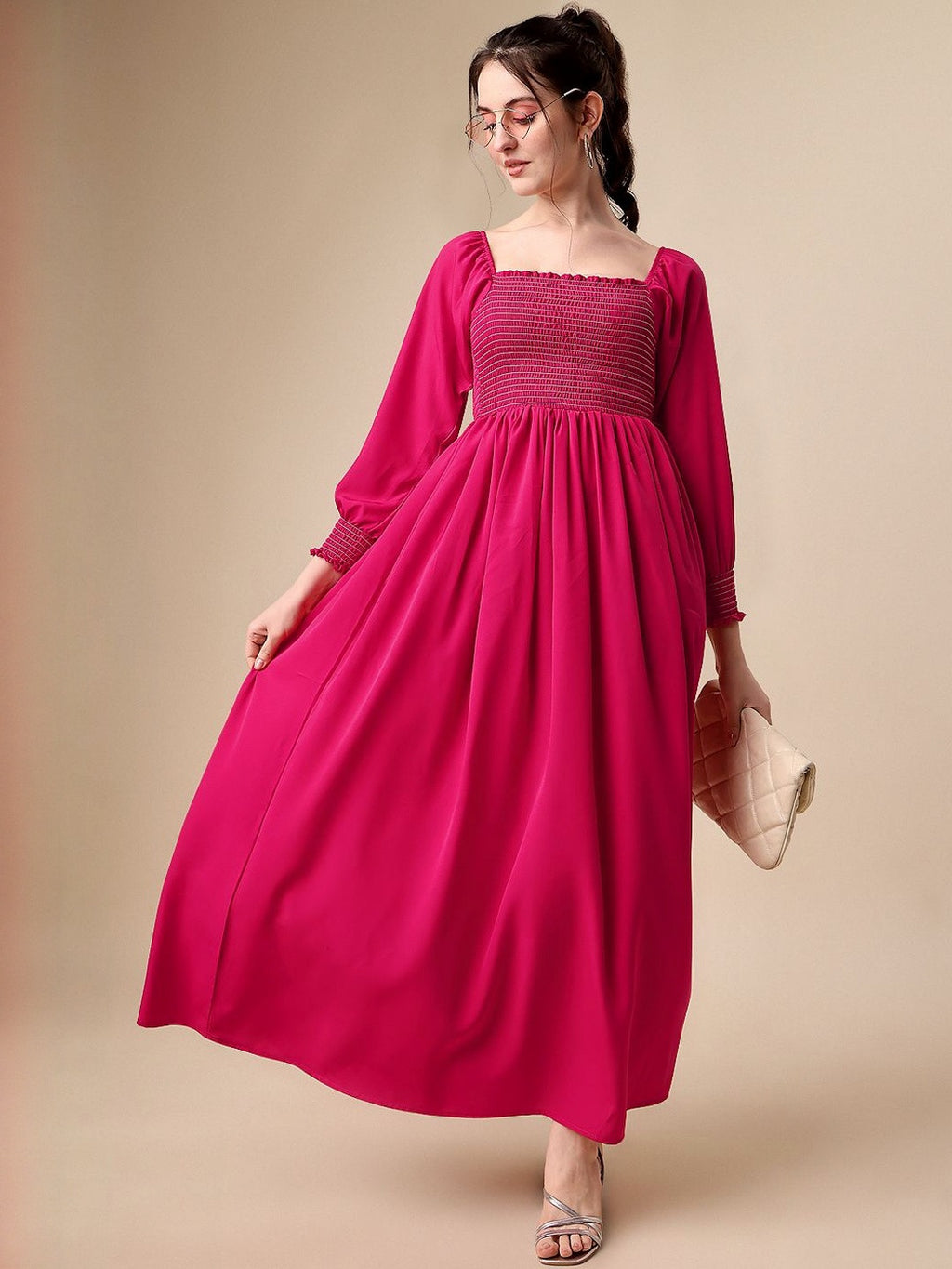 Woman wearing a long fuchsia smocked maxi dress with puff sleeves and silver sandals