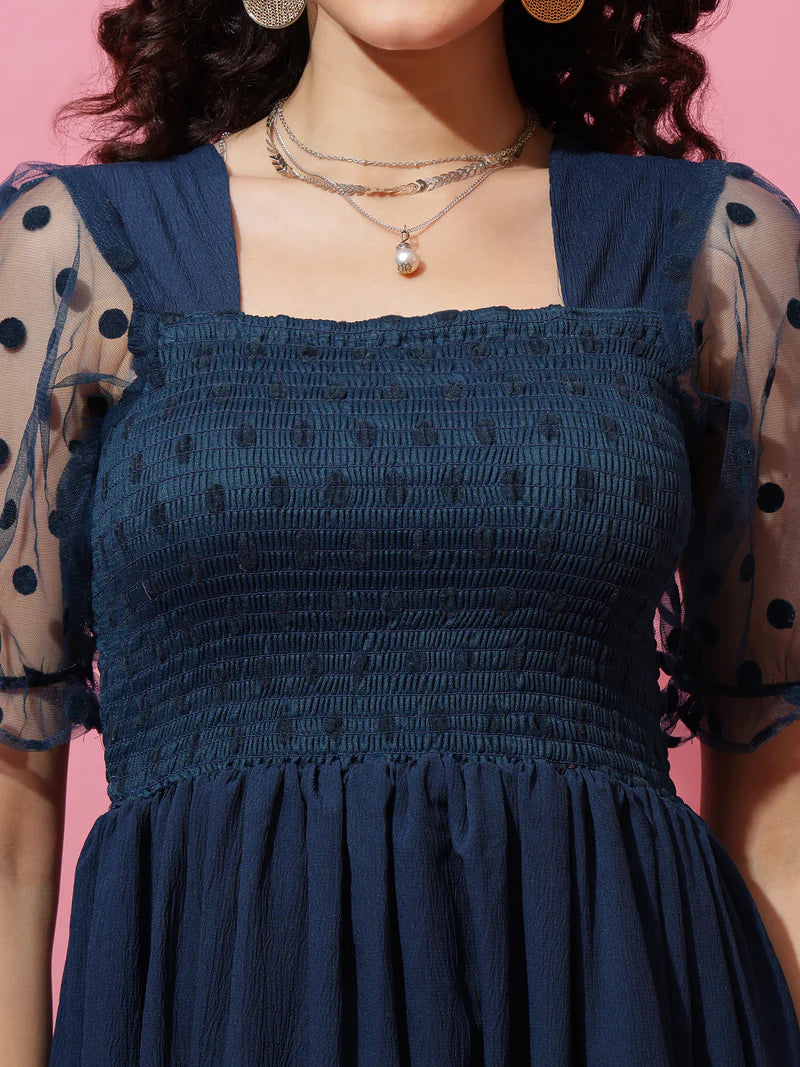Navy blue smocked dress with sheer polka dot sleeves and square neckline